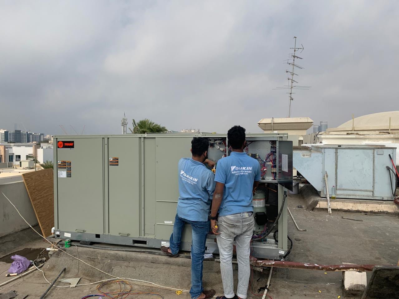 Technicians working on a rooftop AC unit during a compressor replacement in Business Bay, Dubai